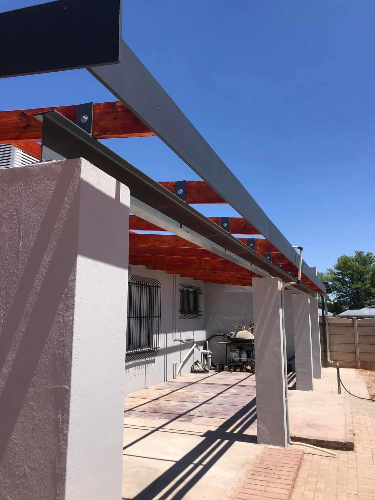 Steel and timber pergola structure with plastered columns