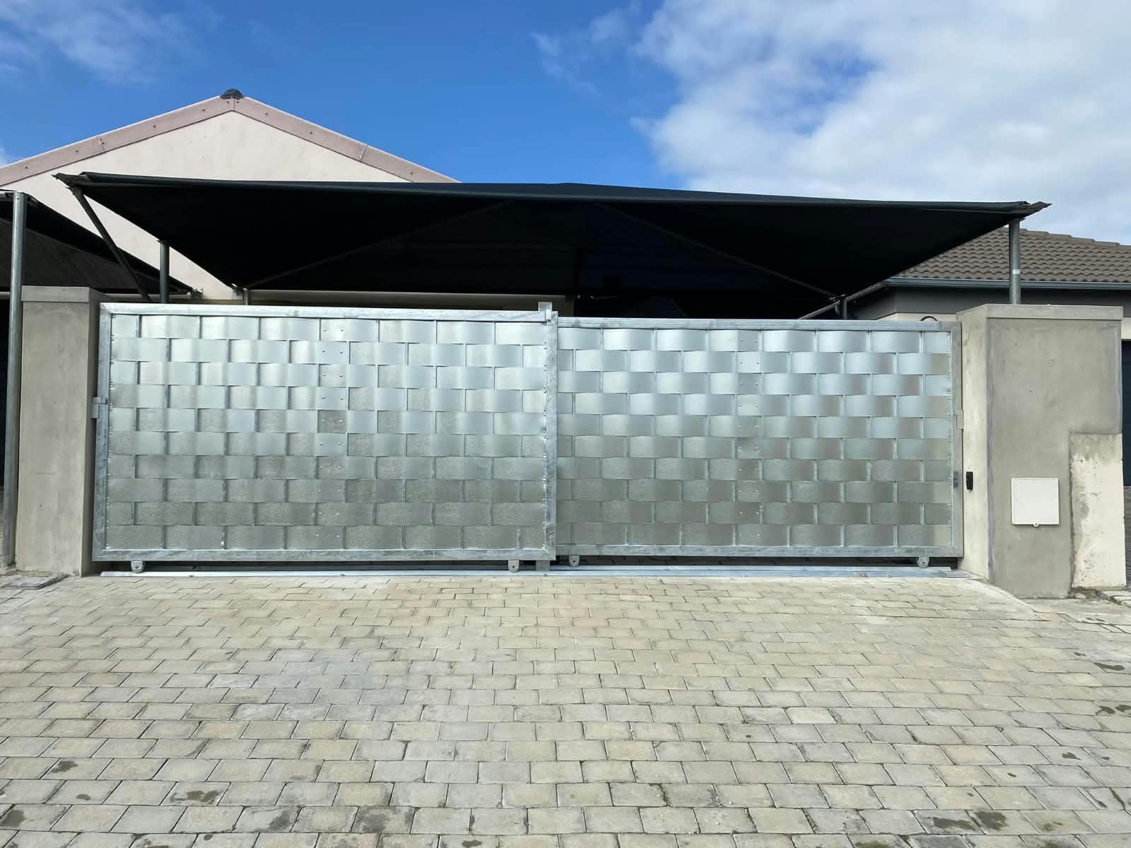 Galvanised woven steel sliding gate at a residential driveway