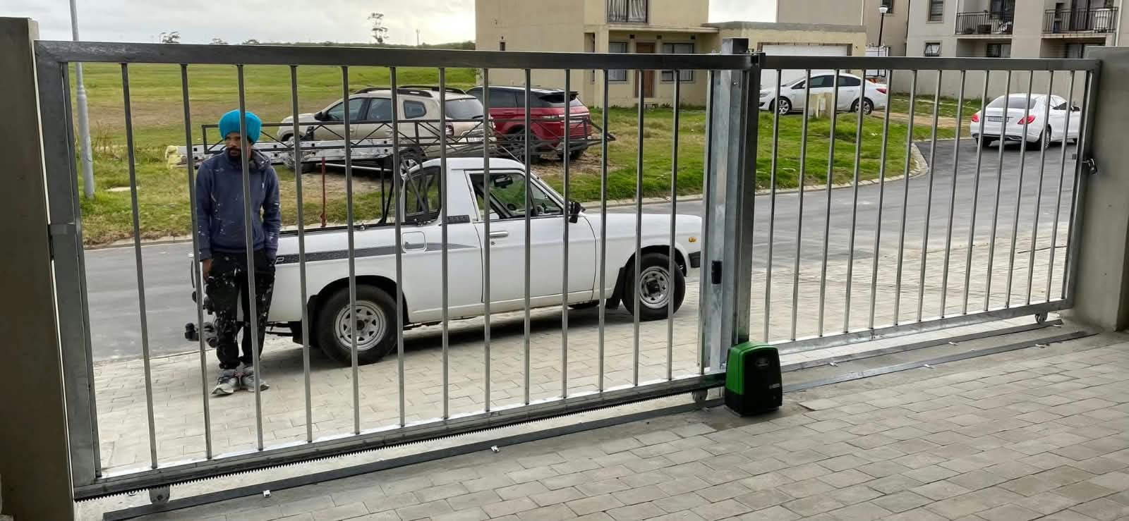 Automated steel sliding gate with motor installed on paving