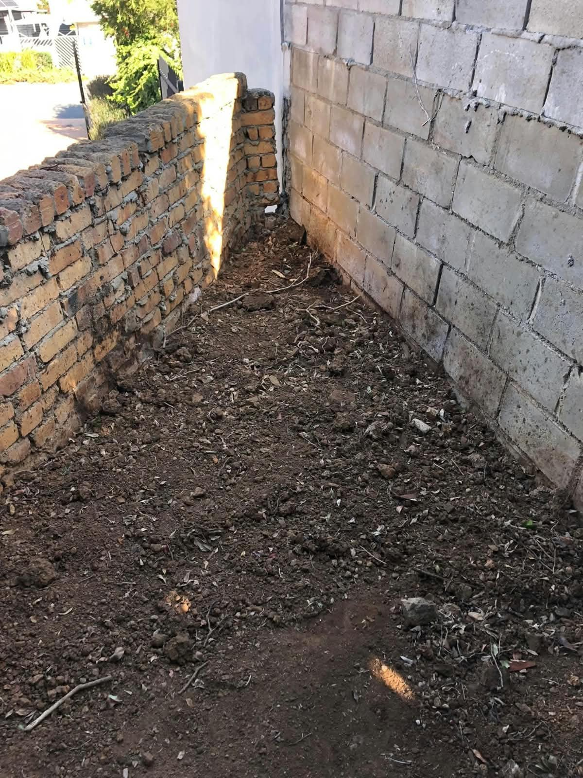 Preparing the ground and brickwork for a boundary wall