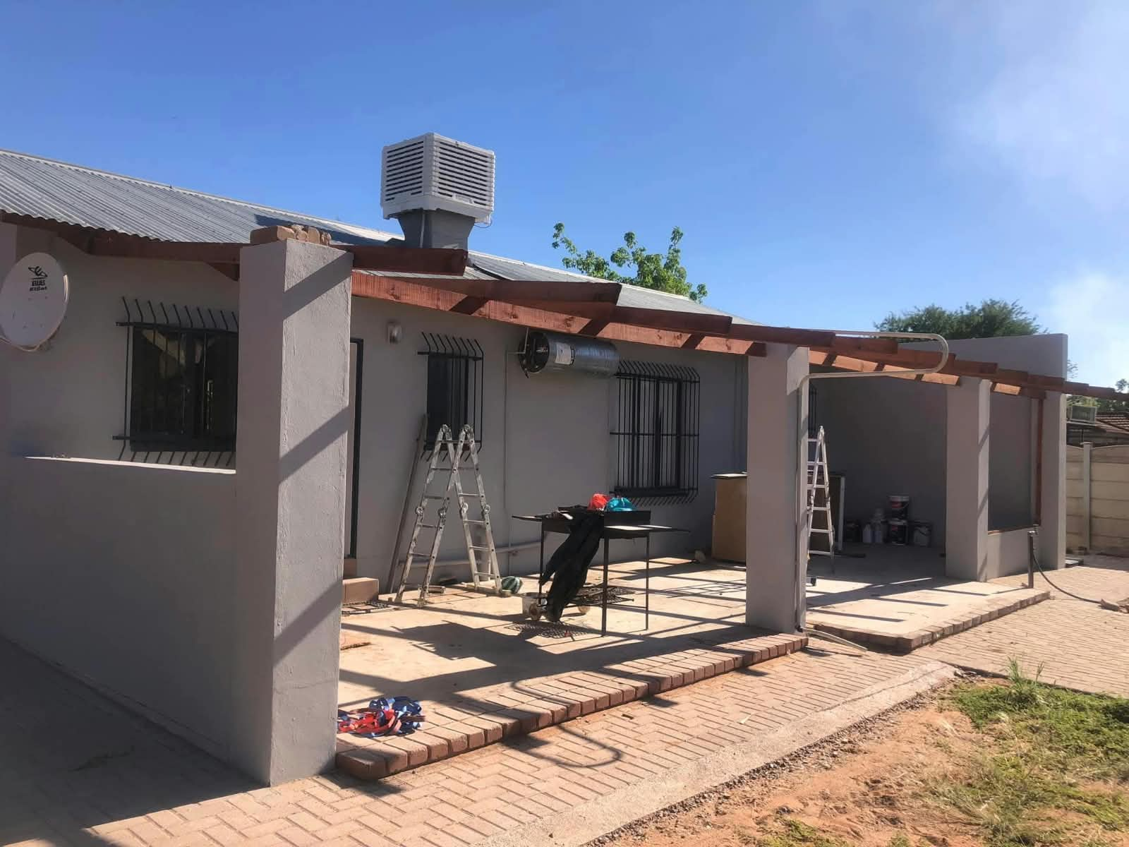 House exterior with pergola and paved patio area