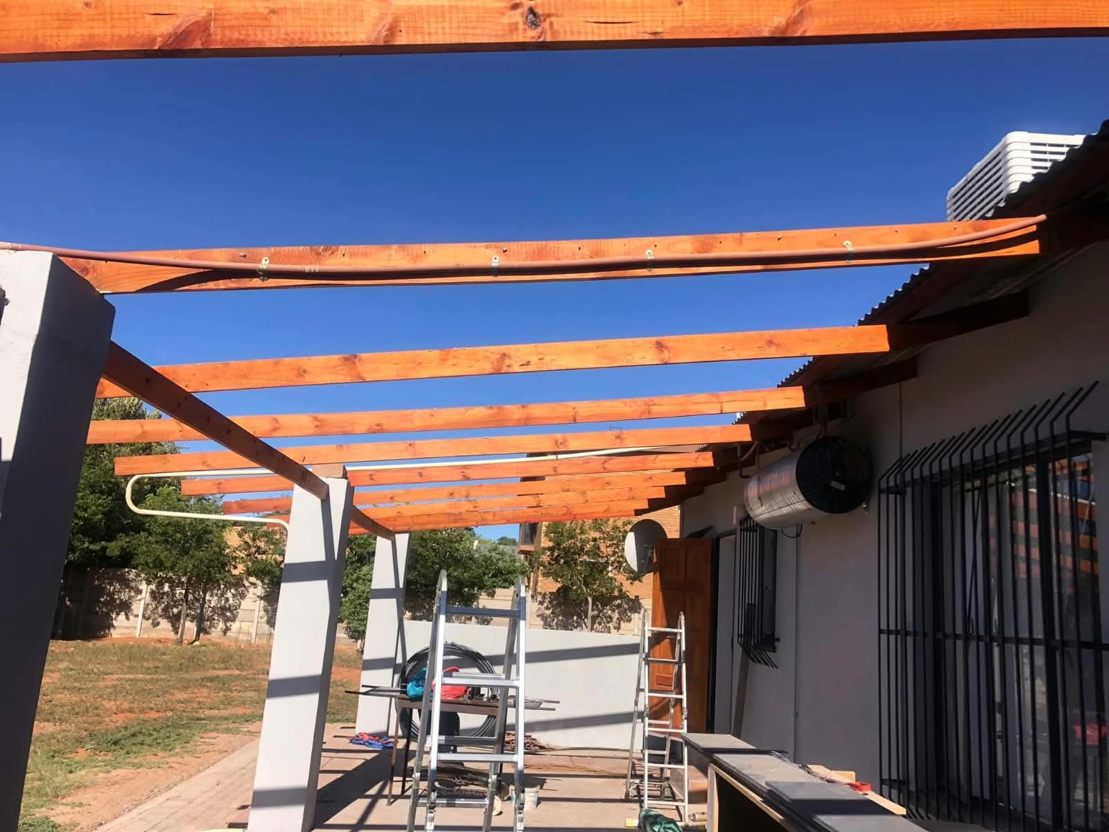 Timber pergola beams installed over a patio
